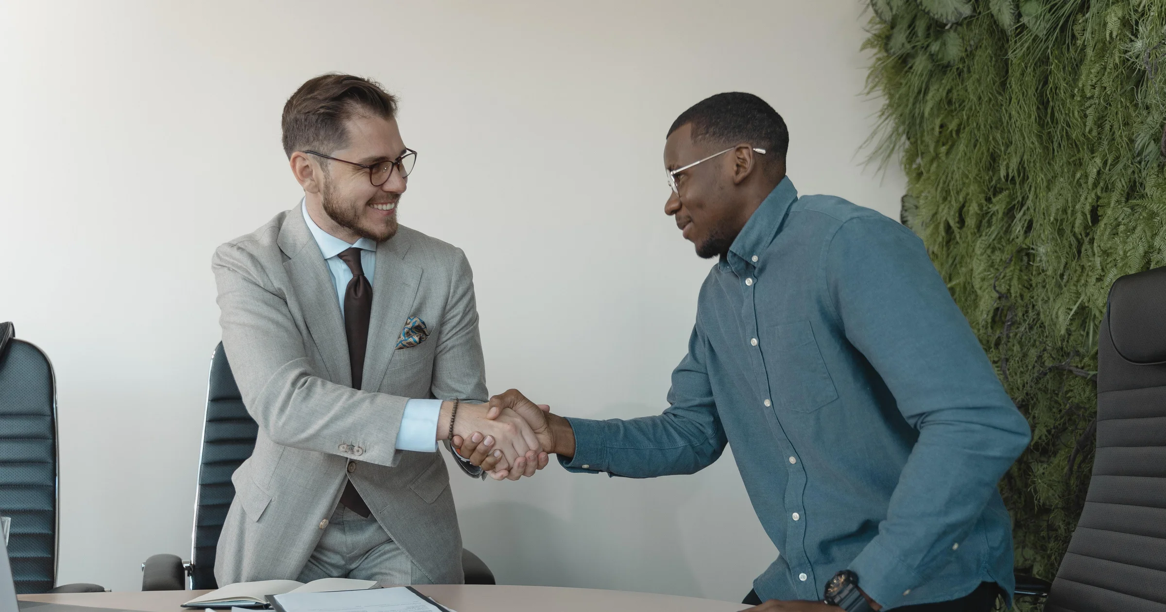 A human resources manager with a notepad in a conference room listening attentively to a job candidate