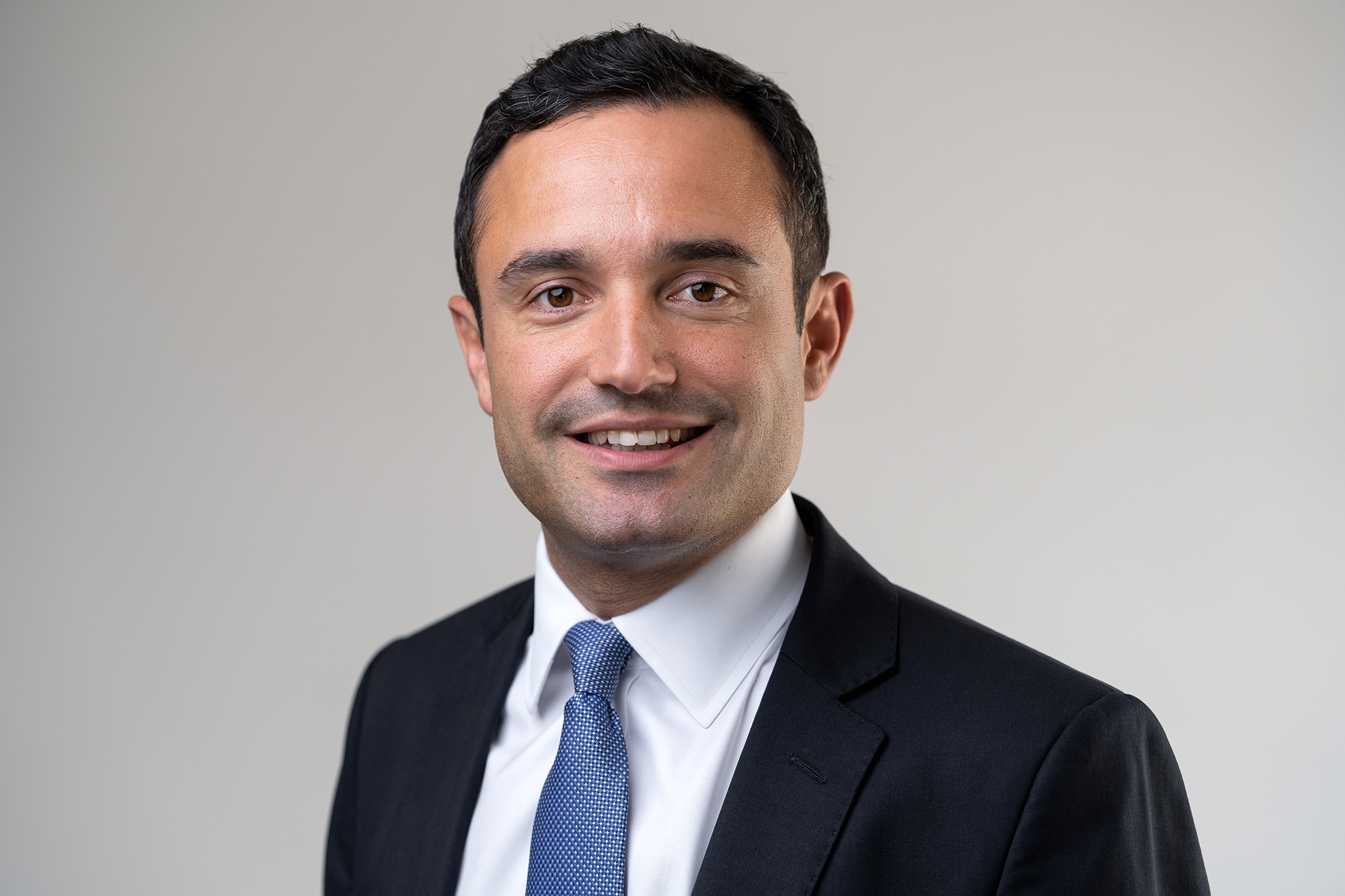 A professional head-and-shoulders headshot with soft lighting and a neutral background